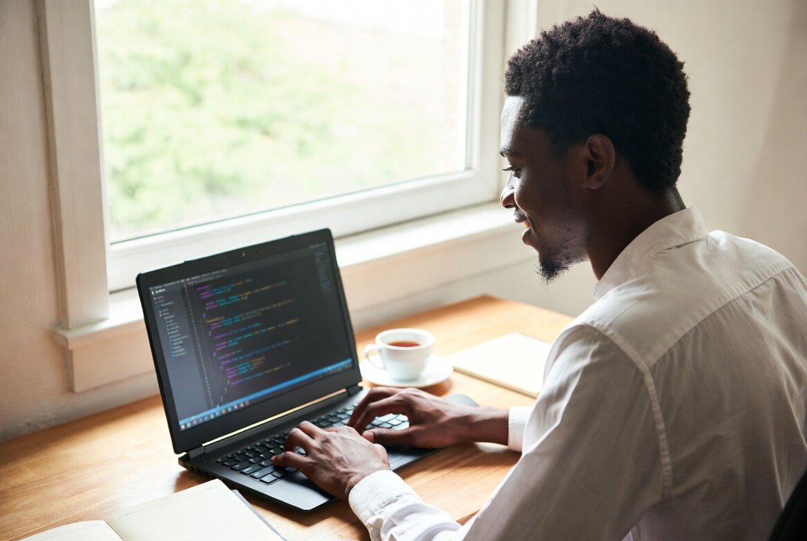 Young Nigerian tech professional building skills on his laptop for study abroad, remote jobs, and international opportunities